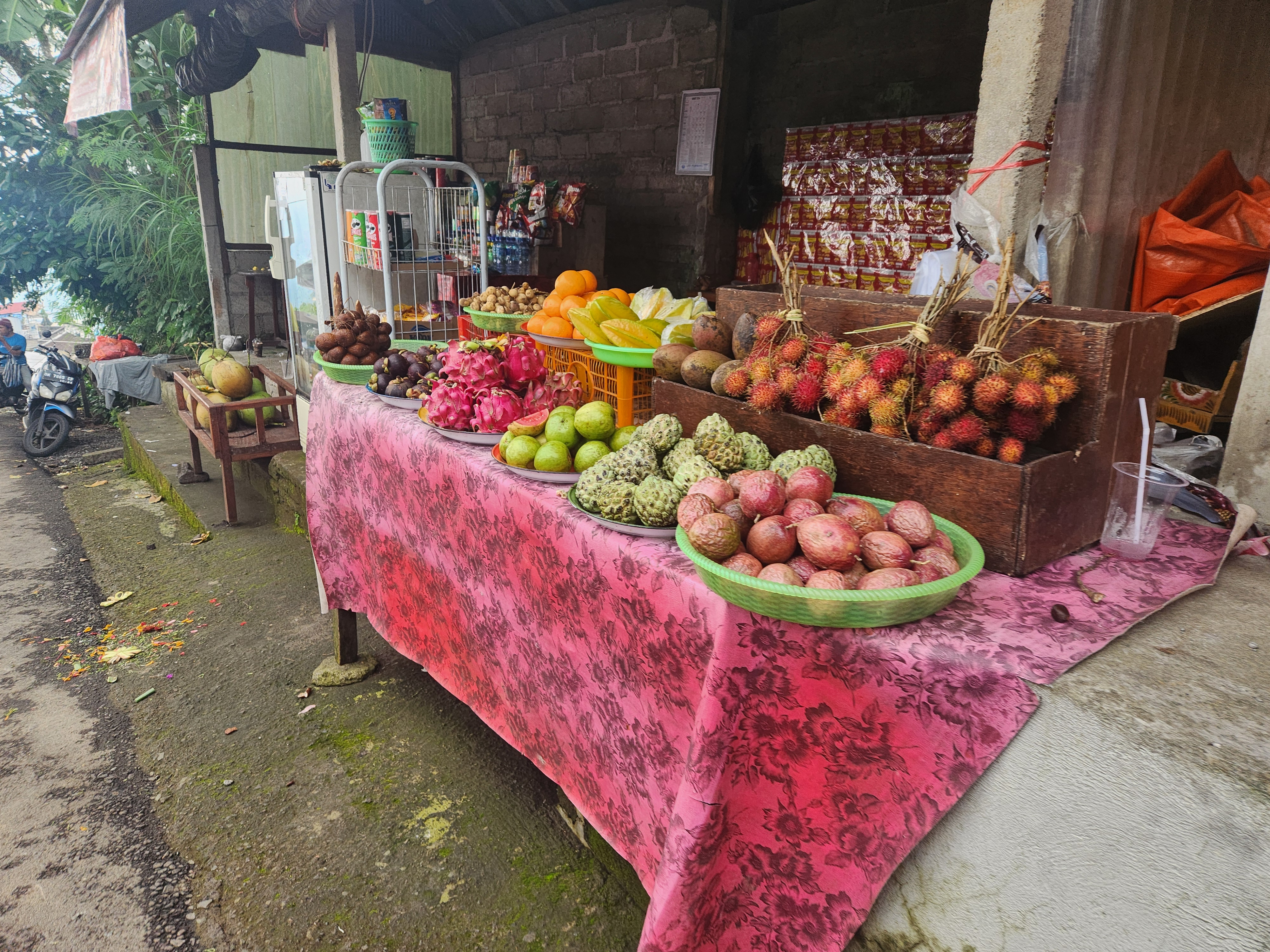 Roadside fruit stand with tropical fruit on a pink cloth in Bali